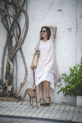 Cheerful female standing with dog near street wall