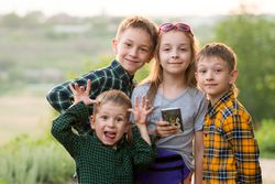 Three brothers and sister sunset together in field