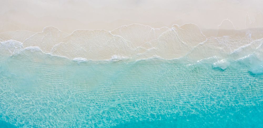 Aerial shot of clear blue water at a tropical beach, wide angle