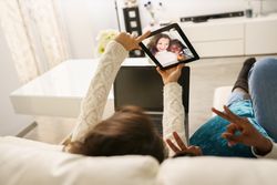 Two women taking selfie in the living room at home
