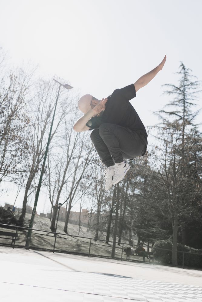 Young man in air dancing break dance in park