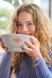 Young woman with bowl of ramen looking at camera