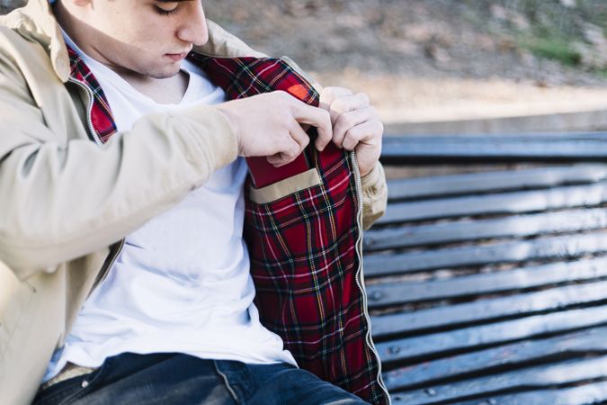 A man tucking his mobile phone into the inside pocket of his jacket