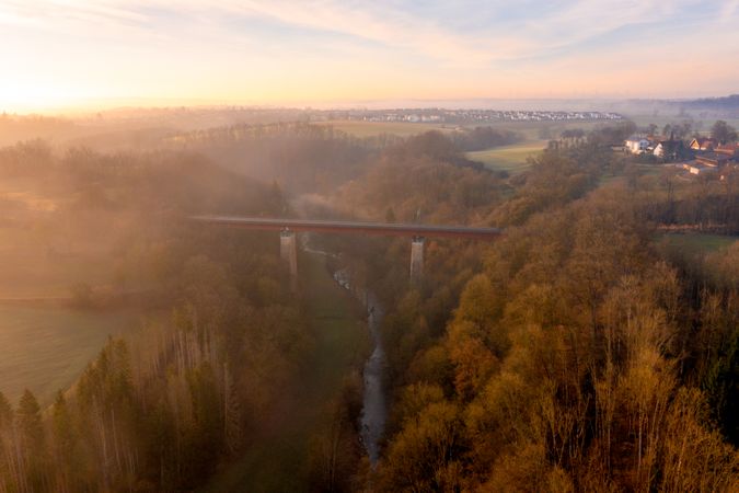 Aerial view at sunrise with train bridge crossing river in the winter nature