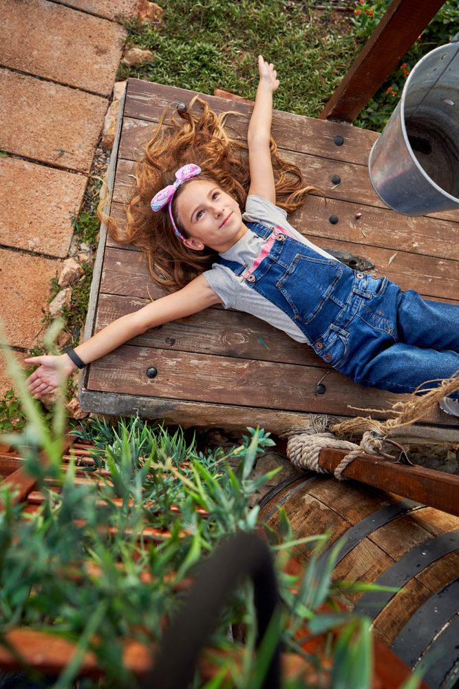 Girl resting on wooden surface in countryside