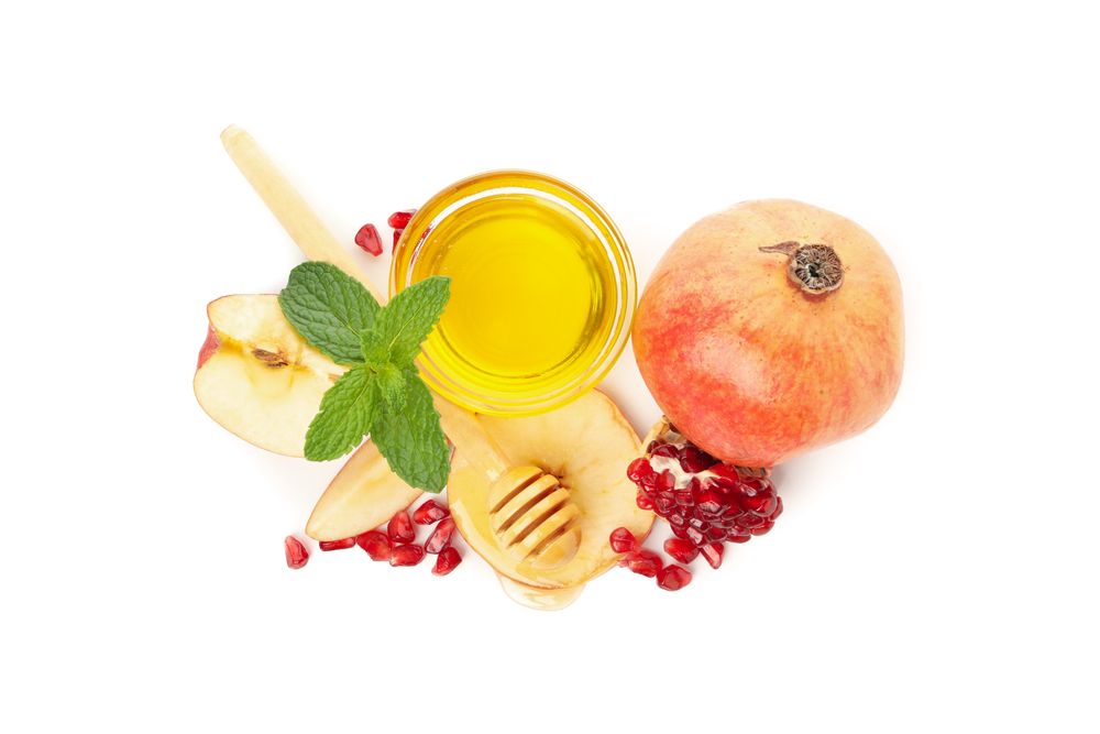 Looking down at honey, pomegranate, mint, and apple