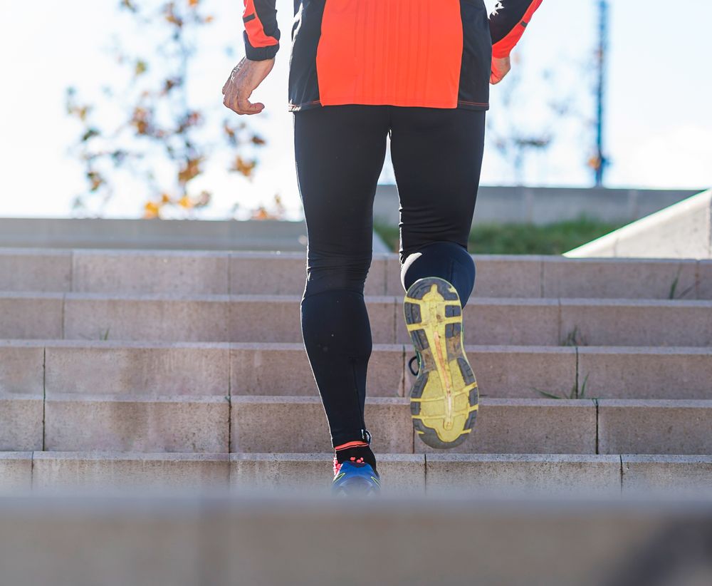 Shoes of active male walking up stairs in park outside