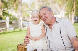 Grandfather and Granddaughter Hugging Outside At The Park