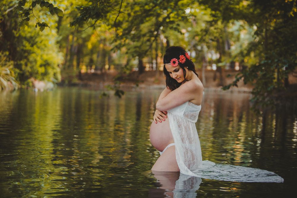 Pregnant woman standing in lake water
