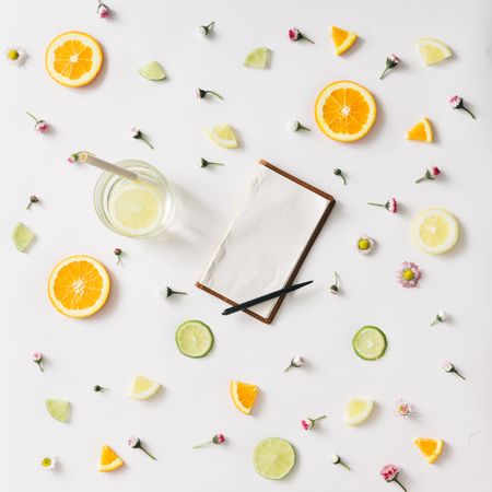 Colorful pattern made of orange, lemon, lime and flowers with old notebook
