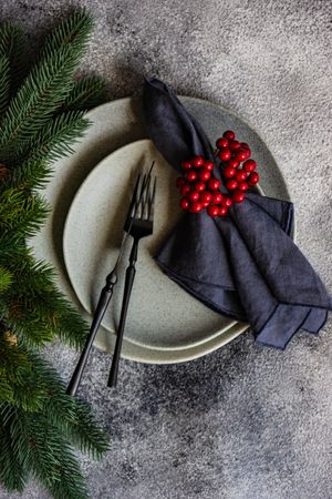 Top view of Christmas table setting with pine branch and holly berries