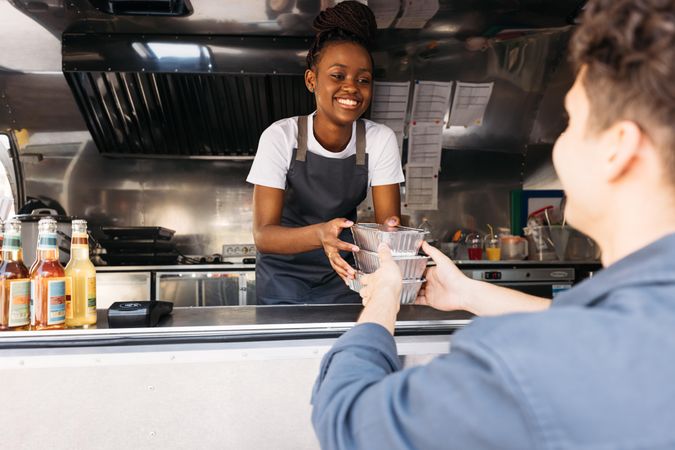 Black woman in apron working at food truck