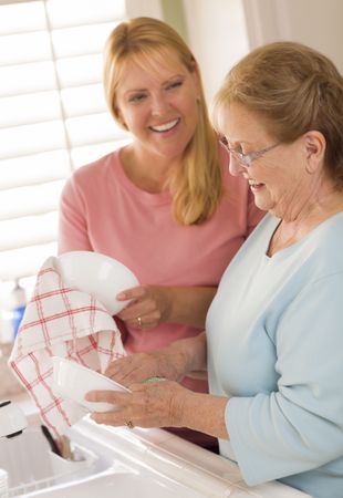 Older Adult Woman and Young Daughter Talking in Kitchen