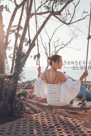 Young woman sitting on swing