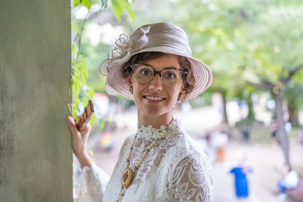 Smiling woman in vintage hat in garden