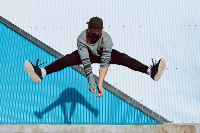 Trendy male flipping and jumping on street