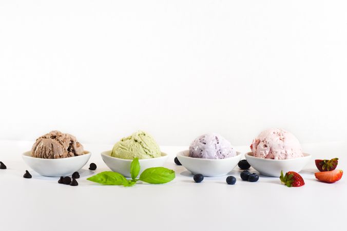 Side view of four small bowls of different flavors of ice cream