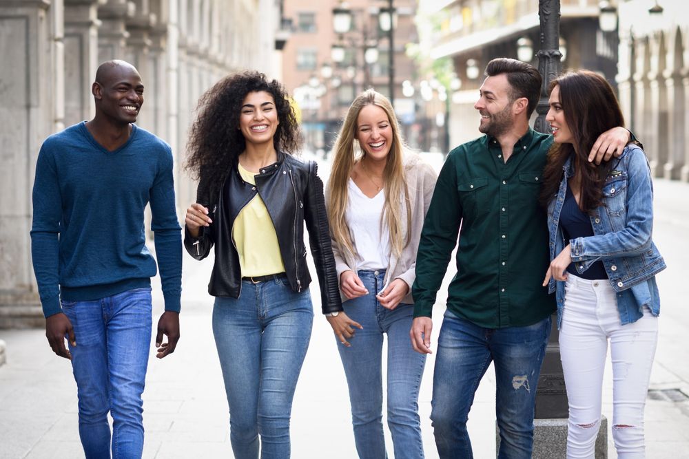 Smiling group of friends walking down city street