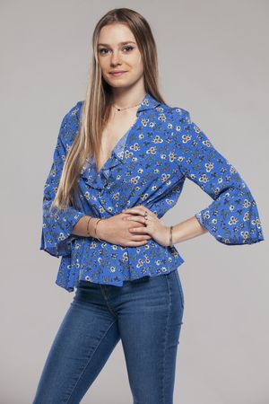 Blonde woman with floral shirt posing in studio