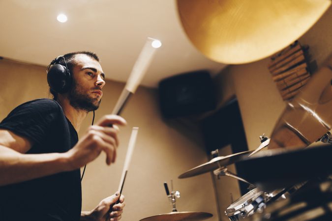 Man with headphones playing on drums