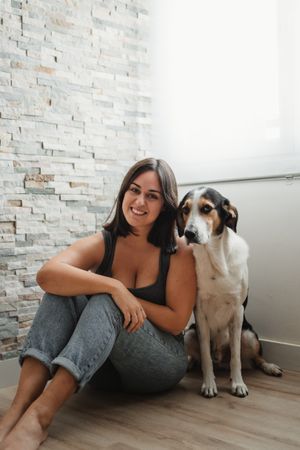 Woman with dog sitting on floor