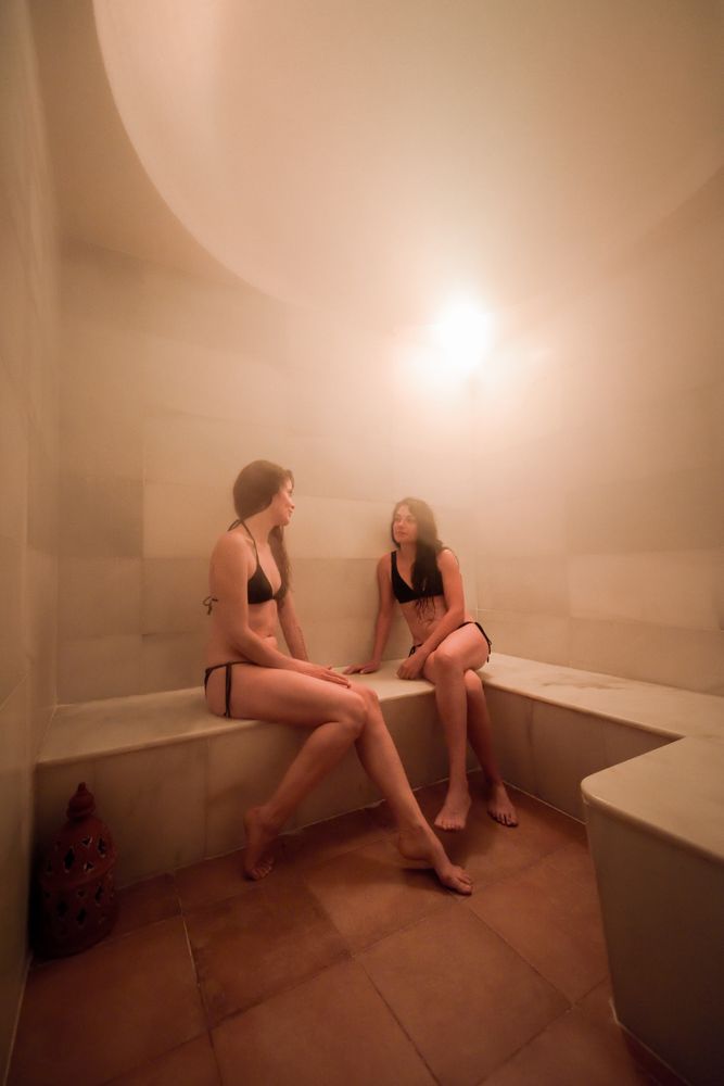 Two friends talking in steam room