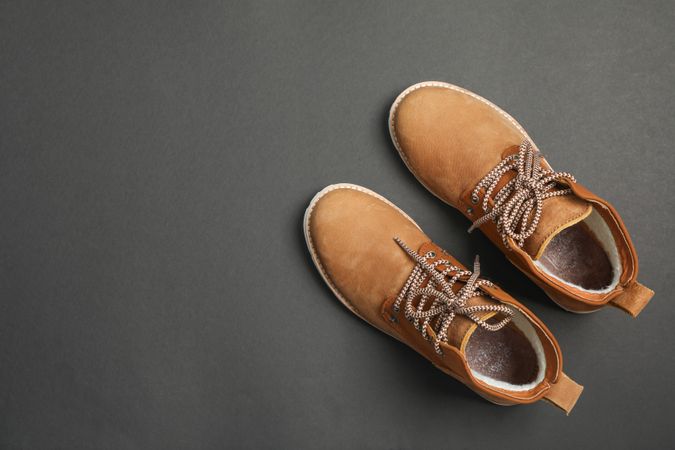 Winter boots on dark background, top view