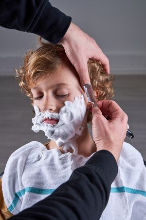 Boy shaving in a barbershop