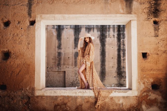 Elegant female in long dress on window