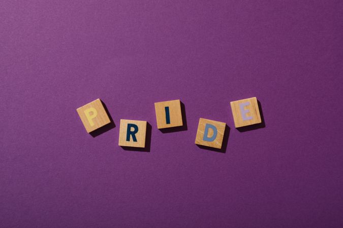 Pride parade concept, compound word on purple background.