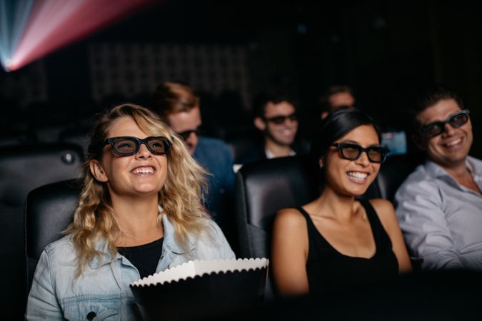 Men and women watching 3d film in theater