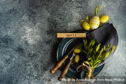Table setting with branch and yellow mini eggs on grey counter with copy space bGR36x