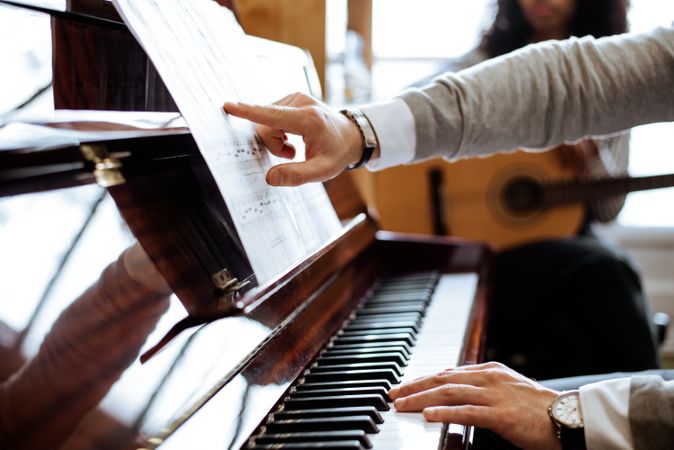 Crop male hands playing piano