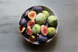 Plate of fresh ripe figs on kitchen table