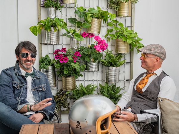 Trendy friends resting at table outdoors
