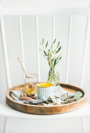 Wood tray with morning latte and raw honey
