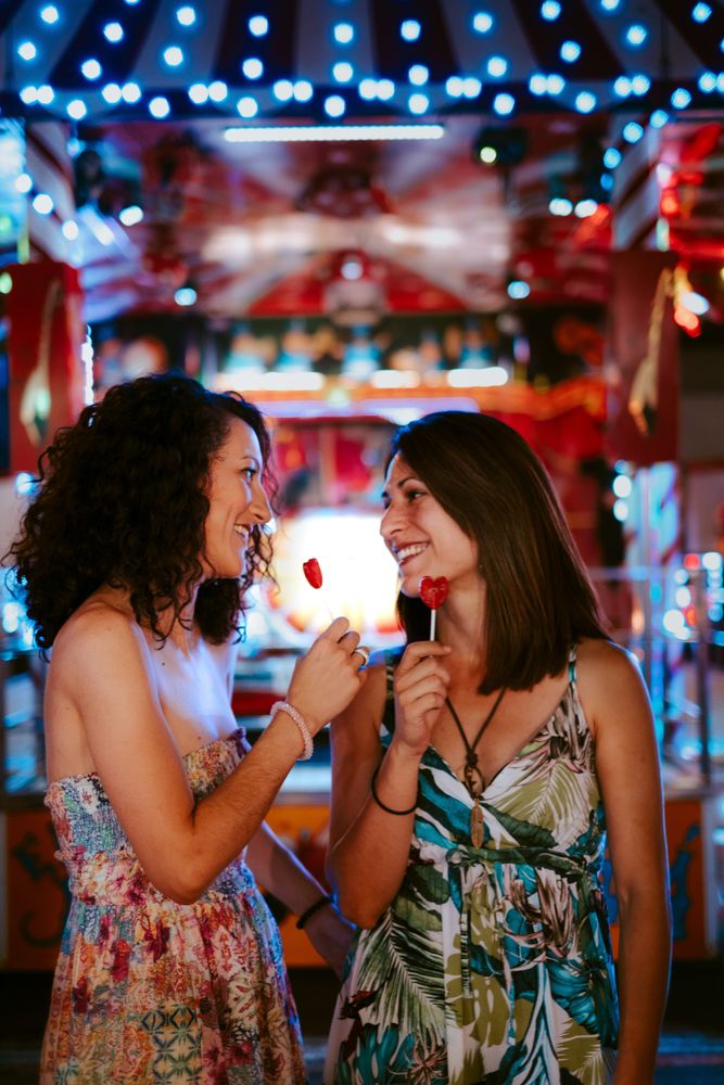 Girlfriends with lollipops in amusement park