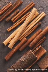 Different sizes of cinnamon sticks on brown background 5XDro5
