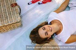 Top view of a smiling woman lying outdoors with eyes closed 4jVXDJ
