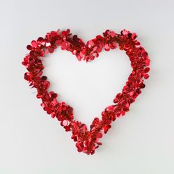 Red confetti shaped in heart outline on light background