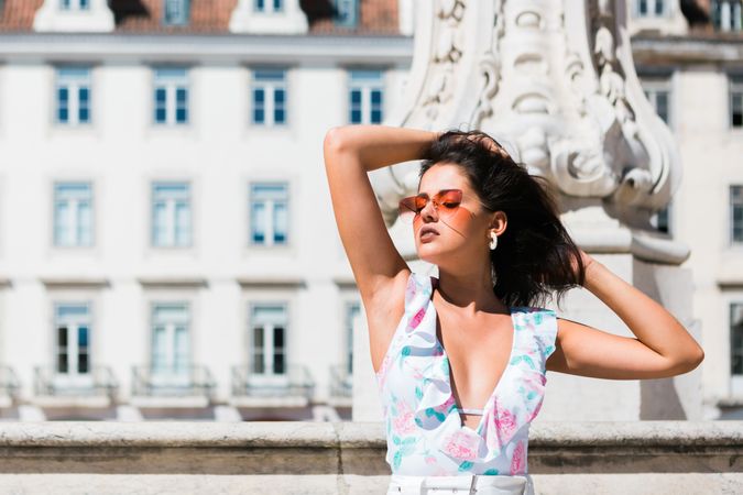 stylish woman in sunglasses sitting in street stairs