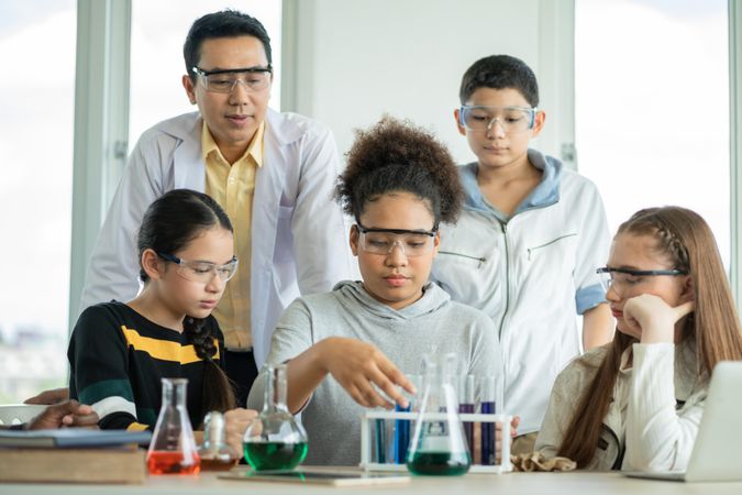 Girl working with beakers in chemistry class