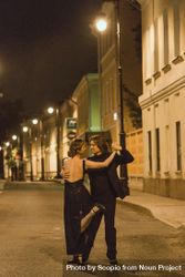 Man and woman dancing tango outdoor in the alley during night time 0yGm14