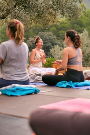 Group of women meditating in Lotus position in nature