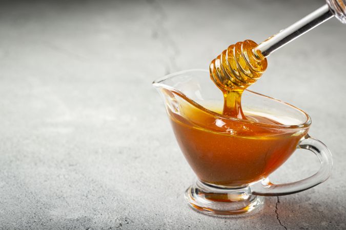 Honey in glass bowl on the table.