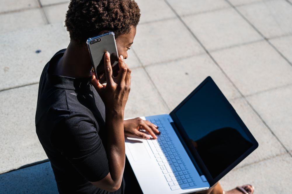 Serious female surfing laptop near modern building