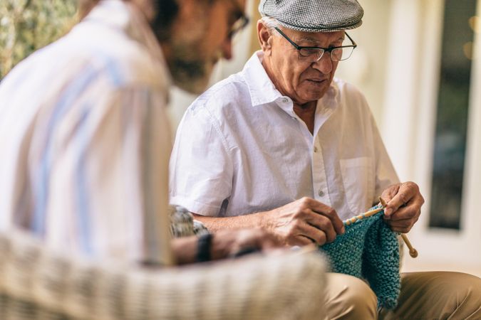Two old men sitting knitting warm clothes