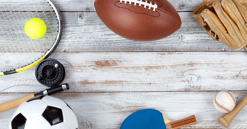Various sports equipment on rustic wooden background