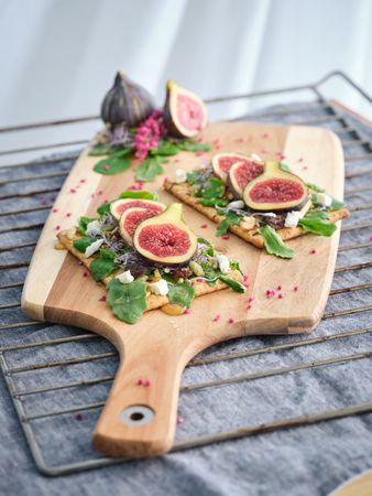 Delicious toast with slices of figs on cutting board