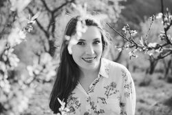 Young happy woman between trees in garden